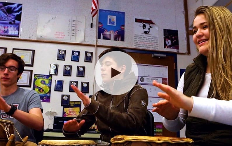 Students playing hand drums in classroom setting