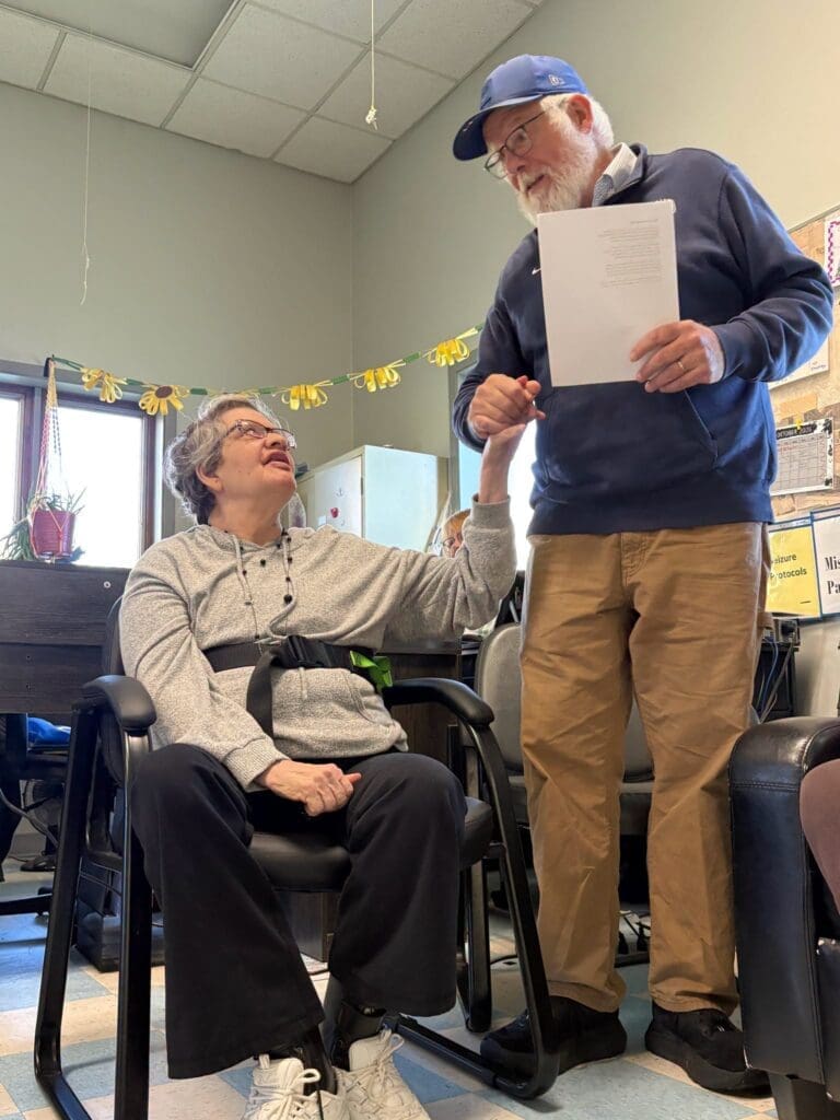 Man holding hands with seated woman