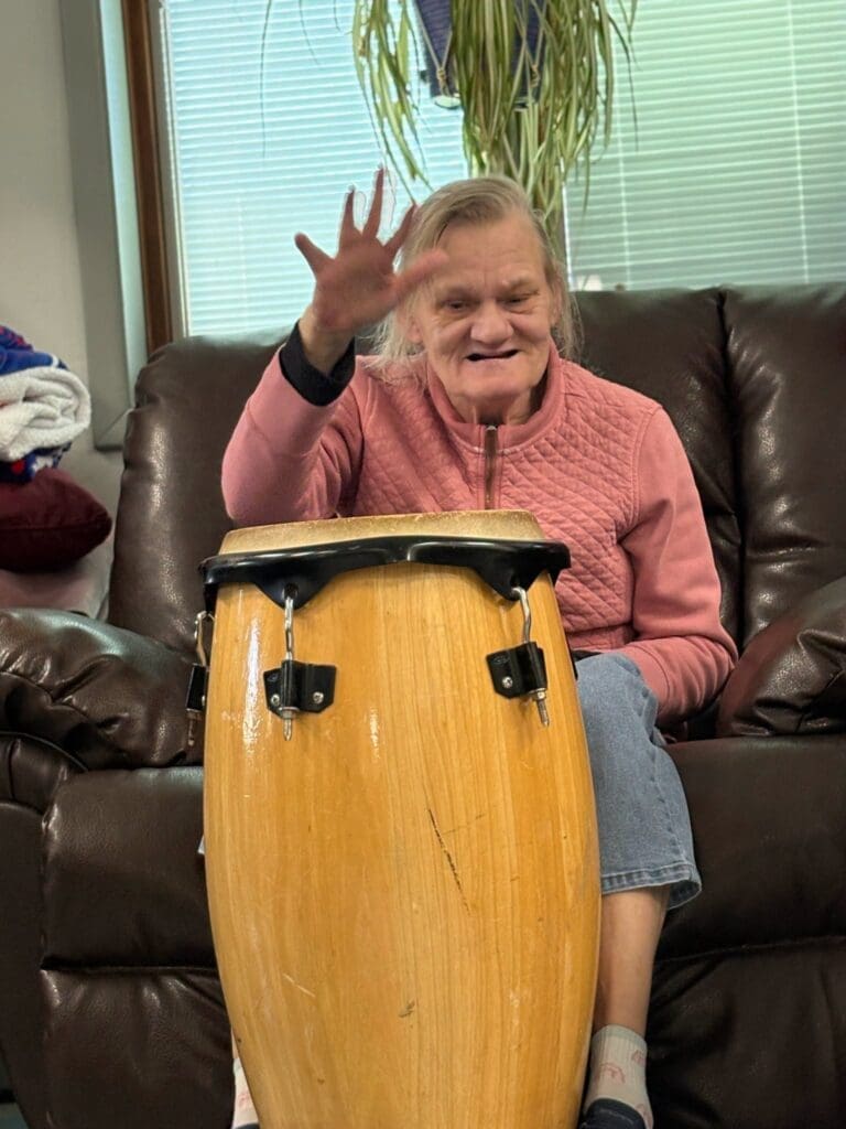 Woman playing a conga drum on couch