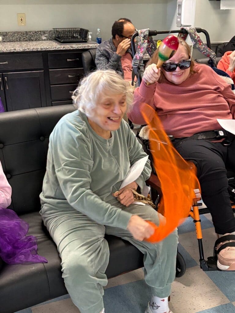 Participants playing with colorful scarves and maracas indoors